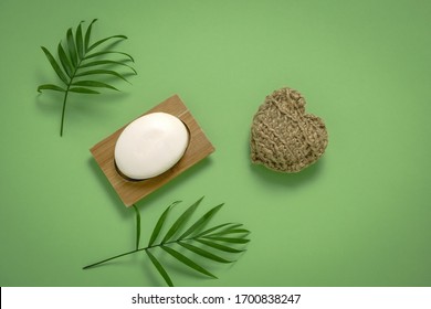 Top View Flatlay Palm Leaves, Soap, Handmade Eco Friendly Jute Washcloth   On A Green Background Copy Space 