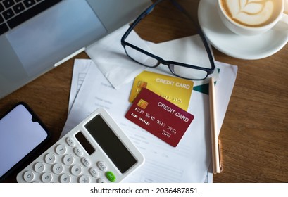 Top View. Focus On Calculator, Lapto And Mobile With Mock Up Credit Card On Bank Statement With Eyeglasses On Table