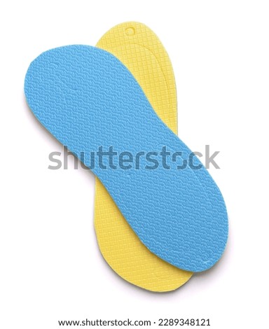Top view of folded blue and yellow disposable foam flip flops isolated on white
