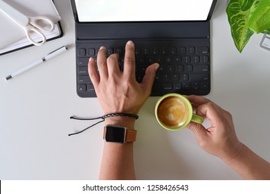 Top view freelance's hand using on keyboard tablet on desk working space.