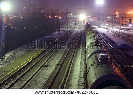 Top view of freight train with tanks on railways at winter night