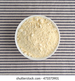 Top View Of French Vanilla Cake Mix In A Bowl On A Striped Tablecloth.