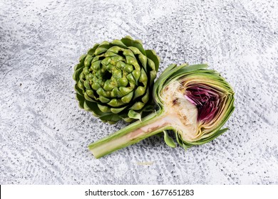 Top view fresh artichoke with slice on light gray background. horizontal