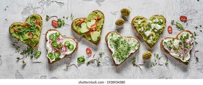 Top View Of Fresh Heart Shaped Bruschettas With Vegetables And Herbs Arranged On Crumbling Stucco Service