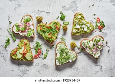 Top View Fresh Heart Shaped Bruschettas With Vegetables And Herbs Placed On Grungy Stucco Service