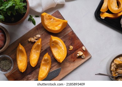 Top view of fresh, orange pumpkin slices on cutting board. Cooking ingredients for a butternut soup, pie or autumn foods. - Powered by Shutterstock