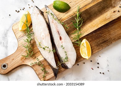 Top View Of Fresh And Raw Halibut Fish Steaks With Herbs And Lemon On Wooden Board. Omega 3 Fats Good For Mental Clarity. Brain Food