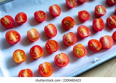 Top view of fresh red cherry tomatoes cut in half, half-cut side up, on the white background, on baking sheet, sprinkle with salt. Preservation, sun-dried tomatoes. - Powered by Shutterstock