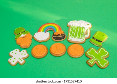 Top View Of Freshly Baked St. Patricks Day Decorated Sugar Cookies On Green Background. Homemade Cookies With Shamrock, Rainbow, Leprechaun And Pot Of Gold Decorations. Irish Holiday