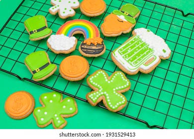 Top View Of Freshly Baked St. Patricks Day Decorated Sugar Cookies On Green Background. Homemade Cookies With Shamrock, Rainbow, Leprechaun And Pot Of Gold Decorations. Irish Holiday