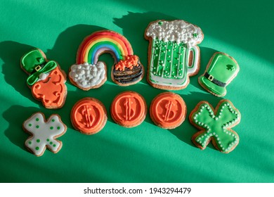 Top View Of Freshly Baked St. Patricks Day Decorated Sugar Cookies On Green Background. Homemade Cookies With Shamrock, Rainbow, Leprechaun And Pot Of Gold Decorations. Irish Holiday.