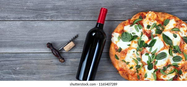 Top View Of Freshly Homemade Cooked Pizza And Red Wine On Rustic Wood