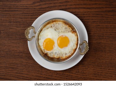 Top View Of Fried Egg In Copper Pan Isolated On Wooden Table