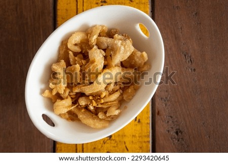 top view of fried pork crackling or pork rind in bowl