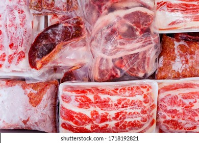 Top view of frozen raw meat wrapped on a box with plastic in the freezer