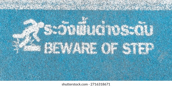 Top view and full frame warning sign of beware of step is served on the ground in public park.