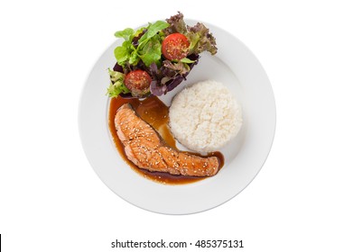 Top View Of Fusion Food Style Grilled Salmon Dressed With Japanese Sweet Sauce (Teriyaki) Including Thai Rice Garnished With Vegetables In Ceramic Dish Isolated On White Background