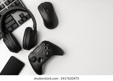 Top view of gamer table with computer keyboard, joystick and headphones