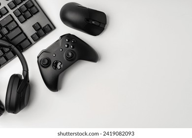 Top view of gamer table with computer keyboard, joystick and headphones