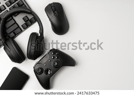 Top view of gamer table with computer keyboard, joystick and headphones
