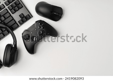 Top view of gamer table with computer keyboard, joystick and headphones