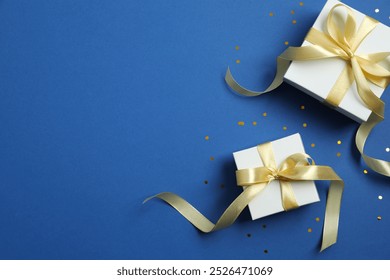 Top view of gift boxes with confetti on color background 