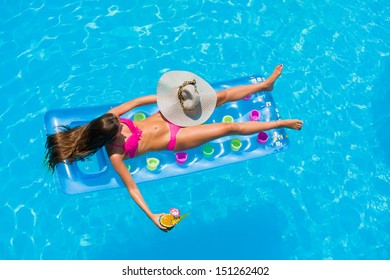 Top View Of A  Girl With Cocktail On A Lilo In The Swimming Pool