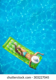 Top View Of A  Girl On A Lilo  In The Swimming Pool