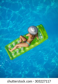 Top View Of A  Girl On A Lilo  In The Swimming Pool