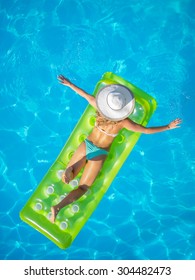 Top View Of A  Girl On A Lilo  In The Swimming Pool