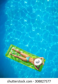 Top view of a  girl on a lilo  in the swimming pool