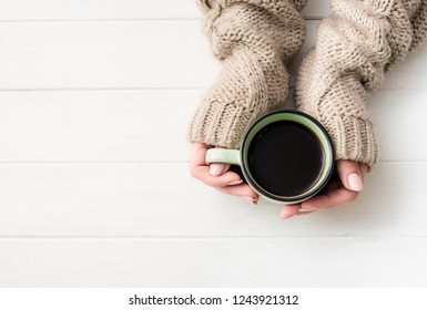 Top View Of Girl In Sweater Holding Coffee Mug On White Table