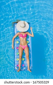 Top View Of A  Girl In The Swimming Pool On A Lilo