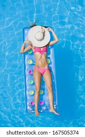 Top View Of A  Girl In The Swimming Pool On A Lilo