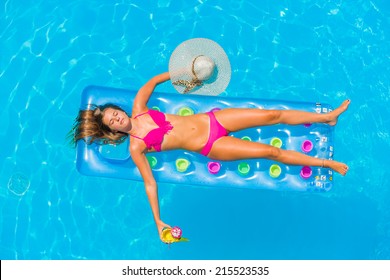 Top View Of A  Girl In The Swimming Pool Relaxing On A Lilo