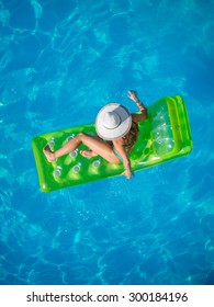 Top View Of A  Girl In The Swimming Pool On A Lilo