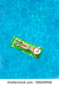 Top View Of A  Girl In The Swimming Pool On A Lilo