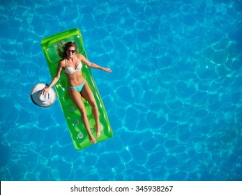 Top View Of A  Girl In The Swimming Pool On A Lilo Air Matress