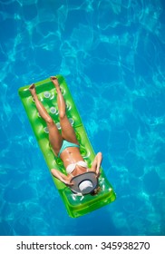 Top View Of A  Girl In The Swimming Pool On A Lilo Air Matress