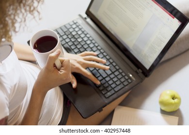 Top View Of Girl Typing On Laptop In Bed