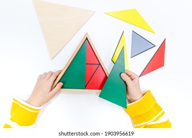 Top view of girls hand is playing and sorting a puzzle of colored wooden geometric shapes in montessori school. Concept of using a mathematical geometry learning resources for children education. - Shutterstock ID 1903956619