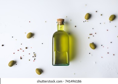Вид сверху стеклянной бутылки с оливковым маслом и оливками, изолированными на белом