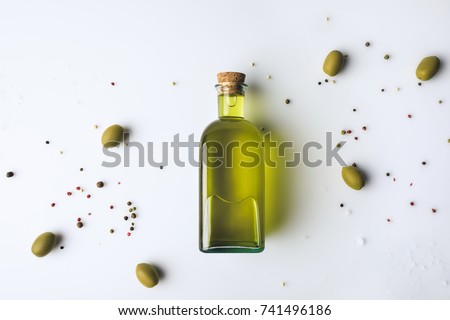 Top view of glass bottle with olive oil and olives isolated on white
