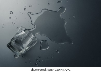 Top view of a glass of water spilled on the table