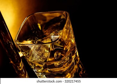 Top Of View Of Glass Of Whiskey Near Bottle On Black Table With Reflection, Warm Light Time Of Relax With Whisky With Space For Text