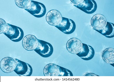 Top View Of Glasses With Pure Water And Shadows On Blue Surface