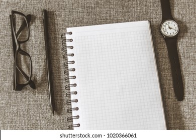 Top view goals list with notebook, pencil, glasses on grey fabric. Flat lay, copy space - Shutterstock ID 1020366061