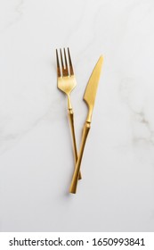 Top View. Gold Knife And Fork For A Festive Table For A Wedding, Birthday Or Party. Concept Of Celebration Table Set. Flatware On White Background.