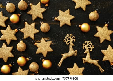 Top View Of Golden Christmas Decorations (balls, Stars, Deers) Over Black Background