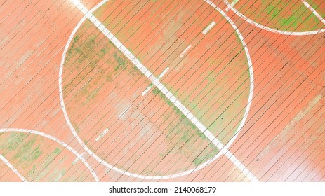 Top View Of The Golden Gun. School Gym With Old Wooden Covering And Multi Colored Paints Of The World, Background Image, Empty Space For Your Slogan, Tinting, Vignetting, Selective Focusing